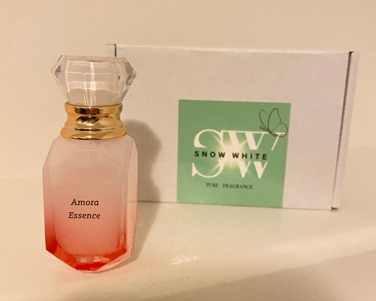 Pink perfume bottle with gold cap on a beige surface, next to a white box with green label.